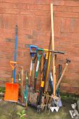 A SELECTION OF GARDEN TOOLS including a Fiskars weed puller, pick axe, forks, shovels, etc