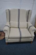 A COX & COX MODEL ANA OVERSIZED WINGBACK ARMCHAIR, with beige upholstery and blue stripes, on