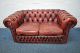 AN OXBLOOD BUTTONED LEATHER TWO SEATER CHESTERFIELD SOFA, length 152cm x depth 89cm x height 66cm (