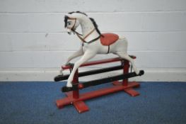 A WHITE PAINTED TRESTLE ROCKING HORSE, of smaller proportions, on a red painted frame, length
