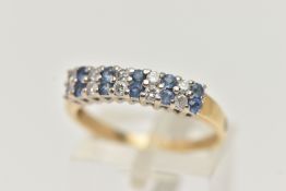 A GEM SET RING, a double row of round brilliant cut diamonds and round cut blue sapphire, prong
