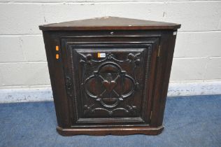 A GEORGIAN OAK HANGING CORNER CUPBOARD, with a later mahogany door panel depicting fleur de lis,