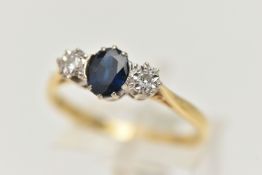 AN 18CT GOLD THREE STONE RING, a principally set oval cut sapphire, with two round brilliant cut