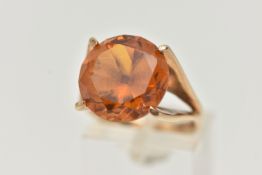 A 9CT GOLD DRESS RING, a large round cut orange stone assessed as synthetic sapphire, set in a