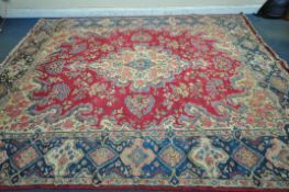 A 20TH CENTURY PERSIAN TABRIZ RUG, the red field with a central cream and floral medallion,