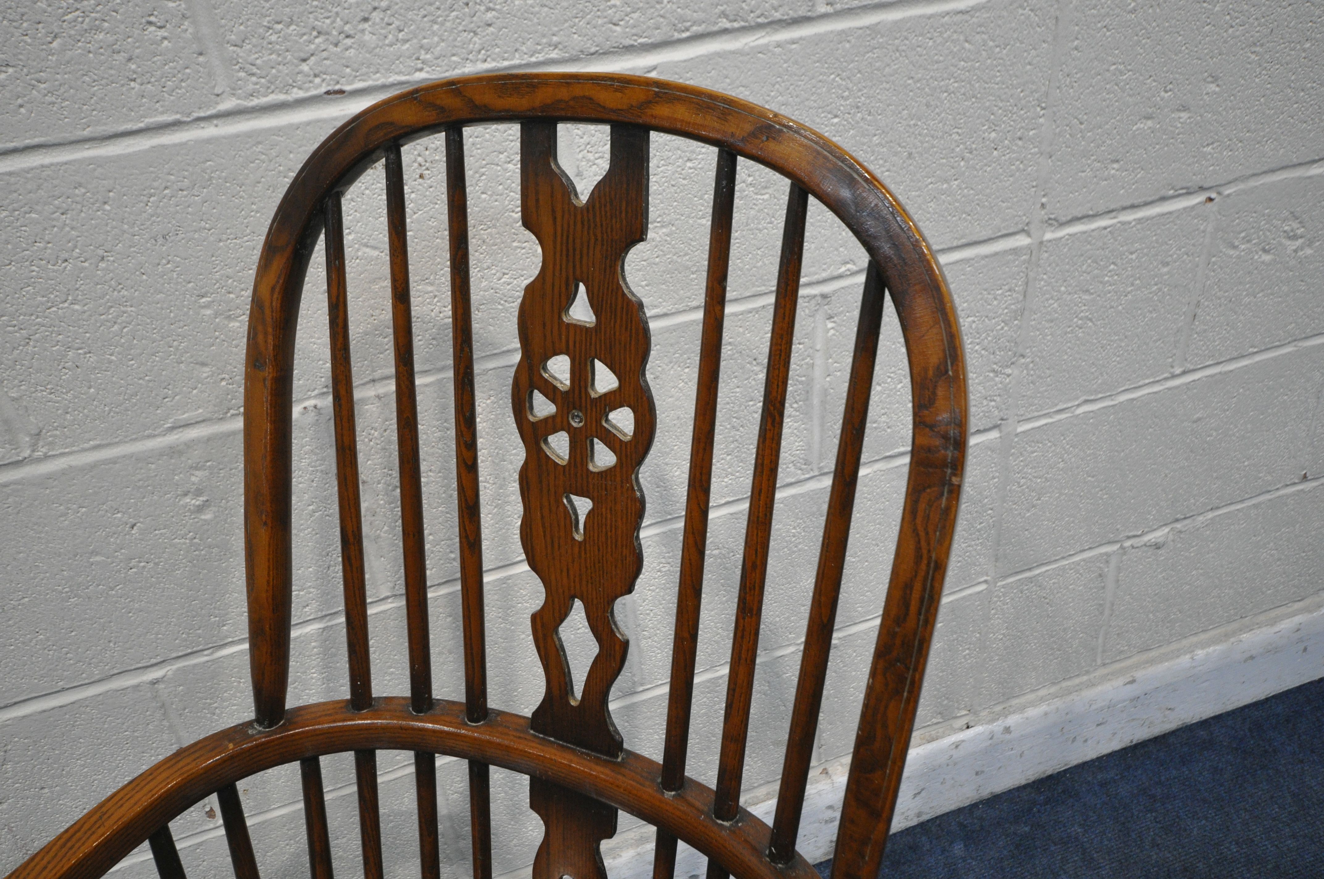 A REPRODUCTION ELM SEATED WHEEL BACK WINDSOR ARMCHAIR, with turned supports and legs, united by a - Image 2 of 3