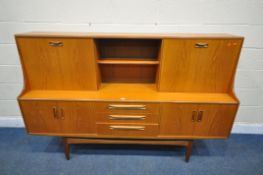 A MID CENTURY TEAK G PLAN HIGHBOARD, fitted with a sliding door and fall front door, above four