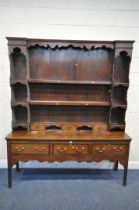 A GEORGIAN OAK DRESSER BASE, fitted with an arrangement of six drawers and two storage sections,