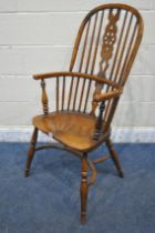 A REPRODUCTION ELM SEATED WHEEL BACK WINDSOR ARMCHAIR, with turned supports and legs, united by a