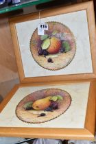 TWO FRAMED HAND PAINTED CERAMIC PLAQUES, signed M. Harnett, painted with fruit in a central circular