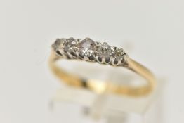 A FIVE STONE DIAMOND RING, five old cut diamonds prong set in white metal, leading on to a yellow