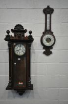 A WALNUT CASED VIENNA WALL CLOCK, with twin finials and central mask, the glazed door enclosing 7