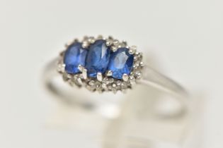 A 9CT WHITE GOLD SAPPHIRE AND DIAMOND RING, designed as three graduated oval sapphires surrounded by