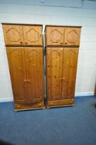 A PAIR OF MODERN PINE DOUBLE DOOR WARDROBES, with a two door top section and a single drawer, on bun