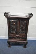 AN ORIENTAL HARDWOOD CABINET, with scrolled raised sides, the panels depicting flowers and