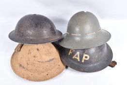 FOUR VARIOUS WWII ERA STEEL HELMETS, these include a civilian Tommy helmet with F.A.P, First Aid
