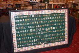 A LARGE FRAMED COLLECTION OF MILITARY CAP BADGES AND COLLAR DOGS, from a wide range of British