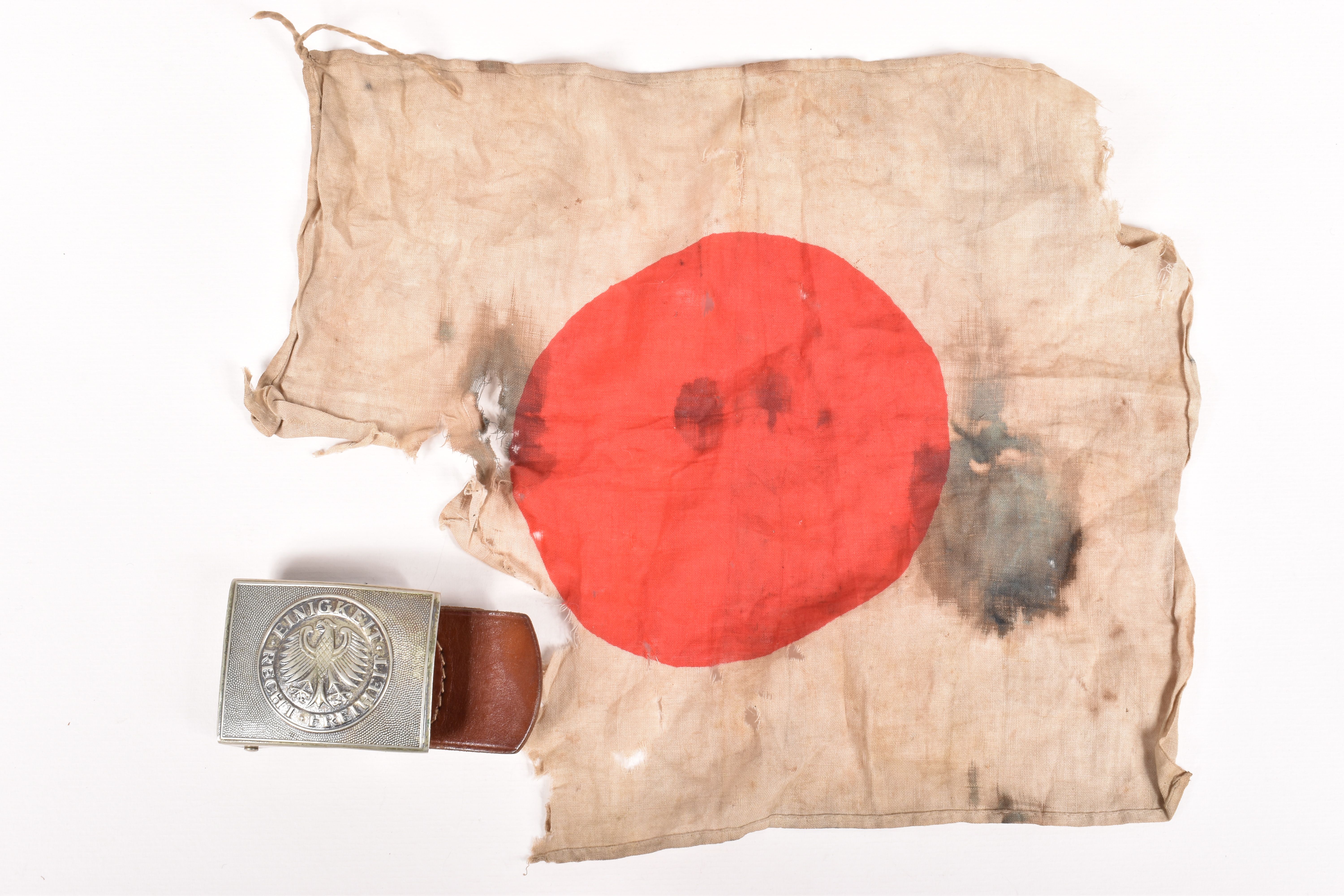 A WWII ERA SMALL JAPANESE FLAG AND A GERMAN BELT BUCKLE, the flag is distressed and the vendor