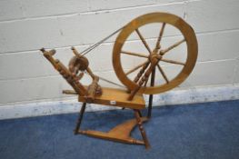 A 20TH CENTURY SPINNING WHEEL (condition report: one spindle broken, wear to both belts, other