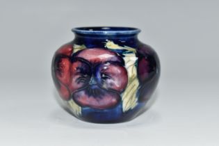 A MOORCROFT POTTERY 'BLUE PANSY' PATTERN SMALL BULBOUS VASE, purple and blue pansies on a dark