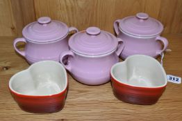 A GROUP OF LE CREUSET, comprising three pale pink stoneware individual casserole dishes with covers,