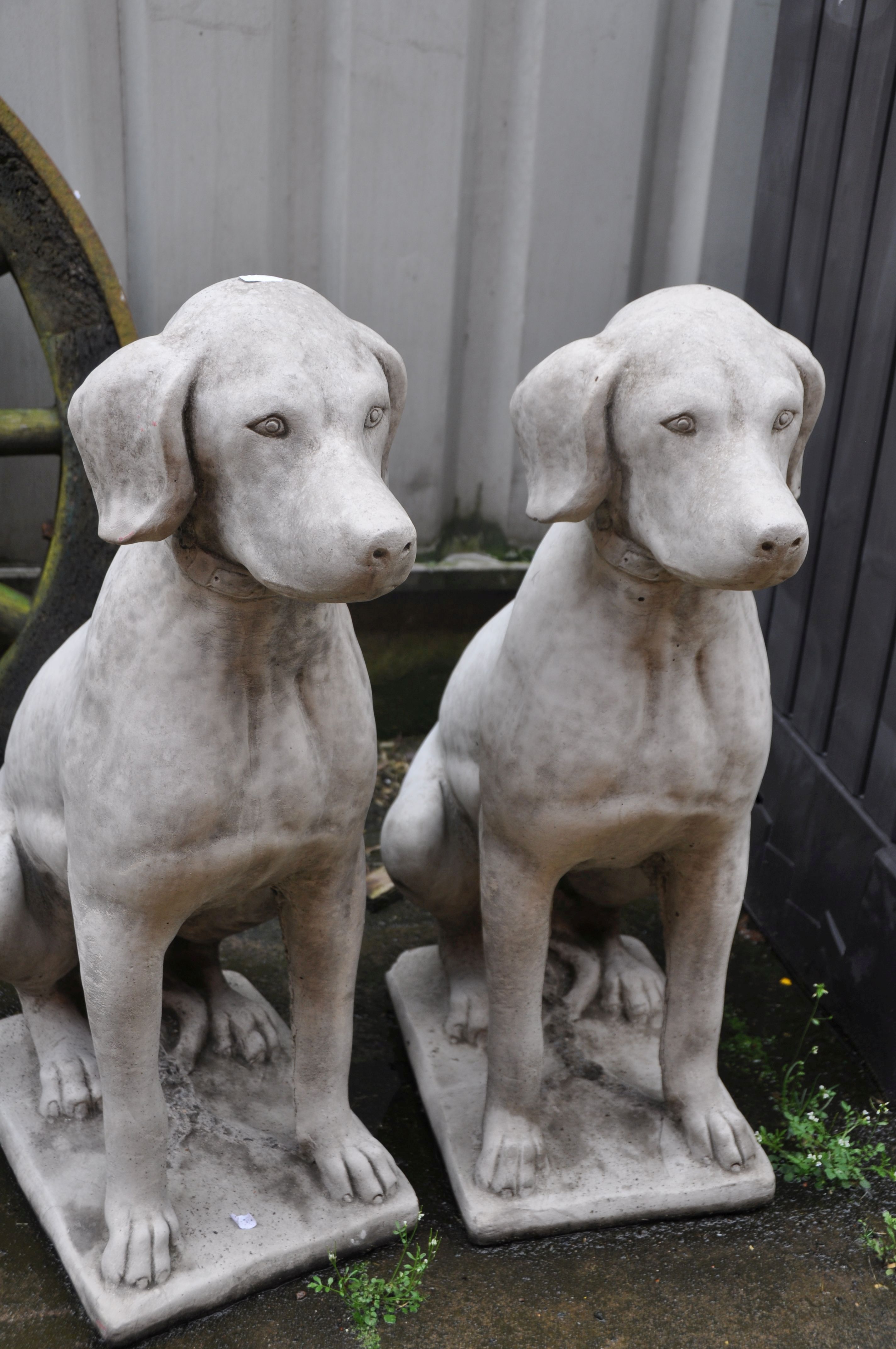 A PAIR OF COMPOSITE GARDEN SITTING DOG STATUES