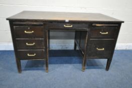 A 20TH CENTURY OAK DESK, fitted with an arrangement of six drawers and two brushing slides, on