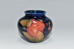 A MOORCROFT POTTERY POMEGRANATE VASE, of squat form, tube lined in Pomegranate pattern on a deep