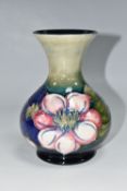 A MOORCROFT POTTERY CLEMATIS VASE, the flared necked vase in 'Clematis' pattern on a graduated green
