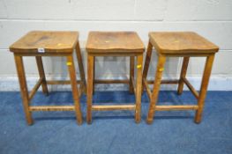 A SET OF THREE EARLY 20TH CENTURY BEECH LAB STOOLS (condition report: surface marks, scuffs,