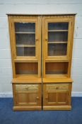 AN ERCOL ELM AND BEECH WALL CABINET, fitted with two glazed doors, above two drawers and two