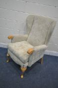 A BARONS BEIGE FOLORAL UPHOLSTERED WINGBACK ARMCHAIR, on front cabriole legs, width 68cm x depth