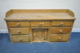 A 19TH CENTURY PINE SIDEBOARD, with a raised back, fitted with an arrangement of seven drawers and a