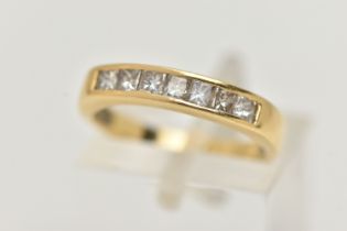AN 18CT GOLD SEVEN STONE DIAMOND RING, designed as seven princess cut diamonds in a channel setting,
