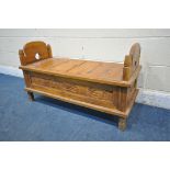 A 20TH CENTURY HARDWOOD BENCH, the twin arched ends with finials, a double hinged storage