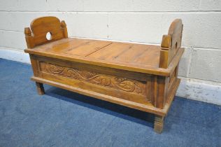 A 20TH CENTURY HARDWOOD BENCH, the twin arched ends with finials, a double hinged storage