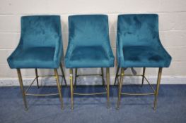 A SET OF FOUR TEAL VELVET UPHOLSTERED BAR STOOLS, with tubular metal legs and handle to rear (