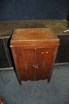 A VINTAGE VALVE RADIO IN A LIDDED OAK CABINET with a battery inside width 54cm depth 35cm height