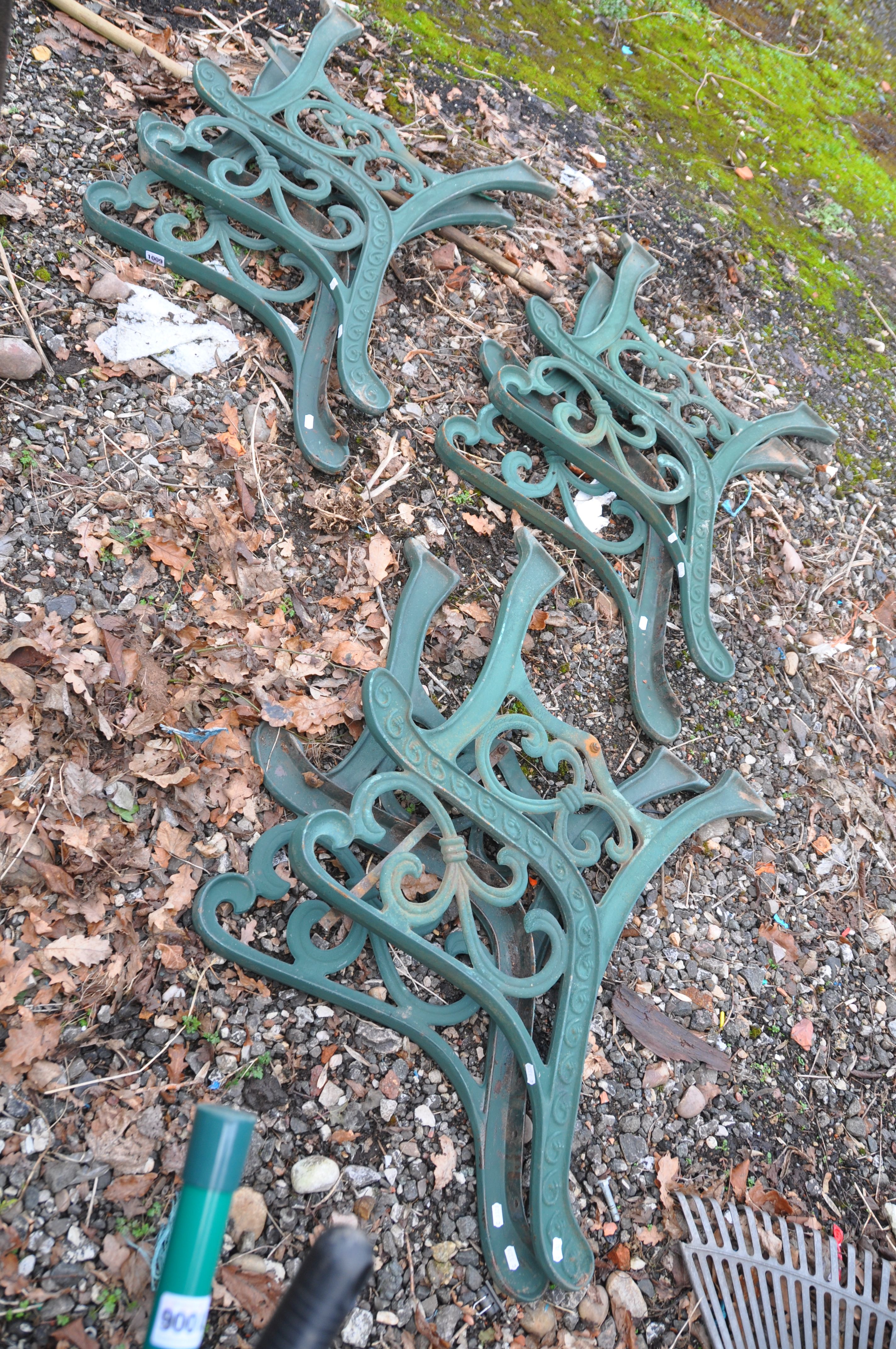 THREE PAIRS OF MODERN CAST IRON BENCH ENDS with green paint scrolled detail