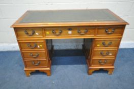A 20TH CENTURY YEW WOOD TWIN PEDESTAL DESK, with a green tooled leather writing surface, fitted with