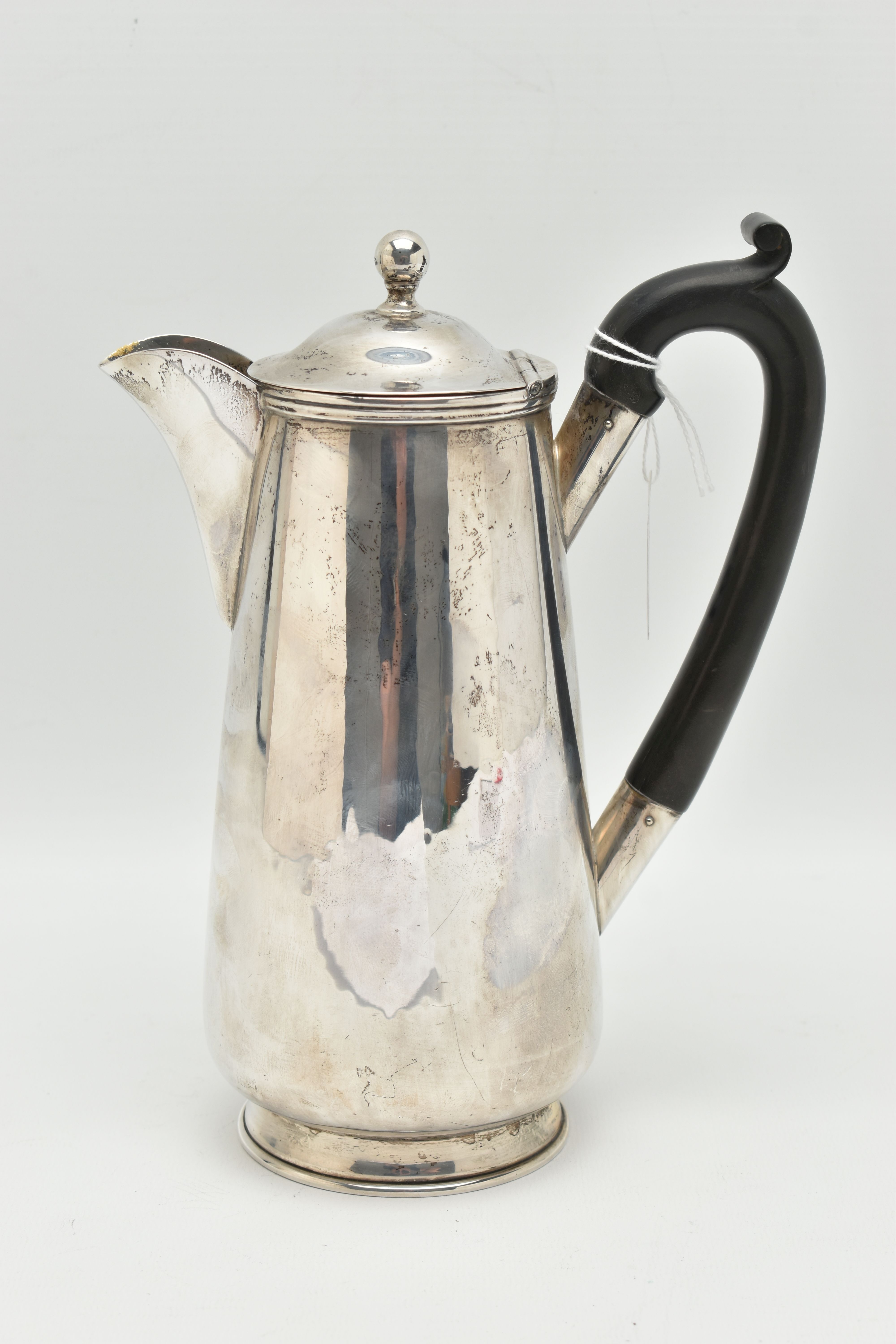 A GEORGE V SILVER WATER JUG, polished form, fitted with an ebonised handle, hinged cover fitted with