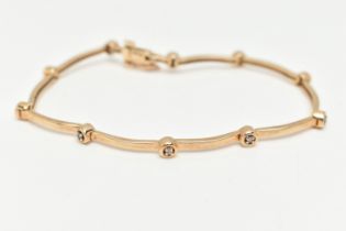 A 9CT YELLOW GOLD DIAMOND BRACELET, designed as a series of ten round brilliant cut diamonds,