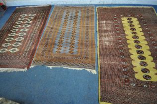 THREE PATTERNED WOOL RUGS, the largest rug with a repeating border, central medallions with a tan