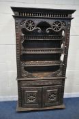 A TALL HARDWOOD WALL CABINET, with a variety of intricate carved designs, consisting of spindles,
