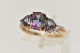 A 9CT GOLD MYSTIC TOPAZ THREE STONE RING, set with a central oval cut mystic topaz flanked with