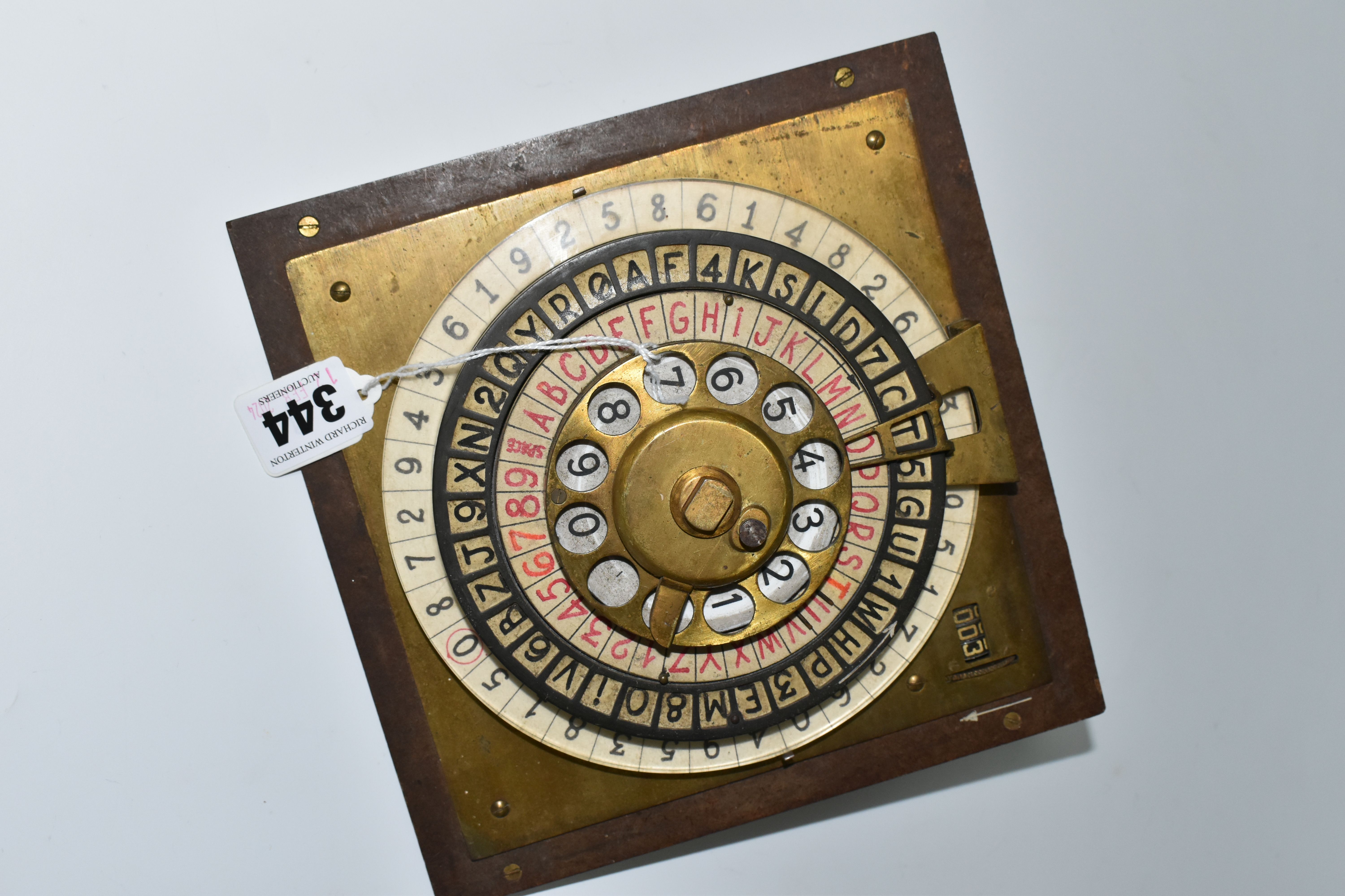 A SCRATCHBUILT DISK CIPHER/CODING MACHINE, with four wheels of letters and numbers, on an angled