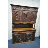 A CARVED OAK BRETON SIDEBOARD, fitted with an arrangement of five panel doors, depicting humans in
