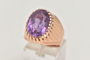A SYNTHETIC COLOUR CHANGE SAPPHIRE SIGNET RING, designed as an oval purple synthetic colour change