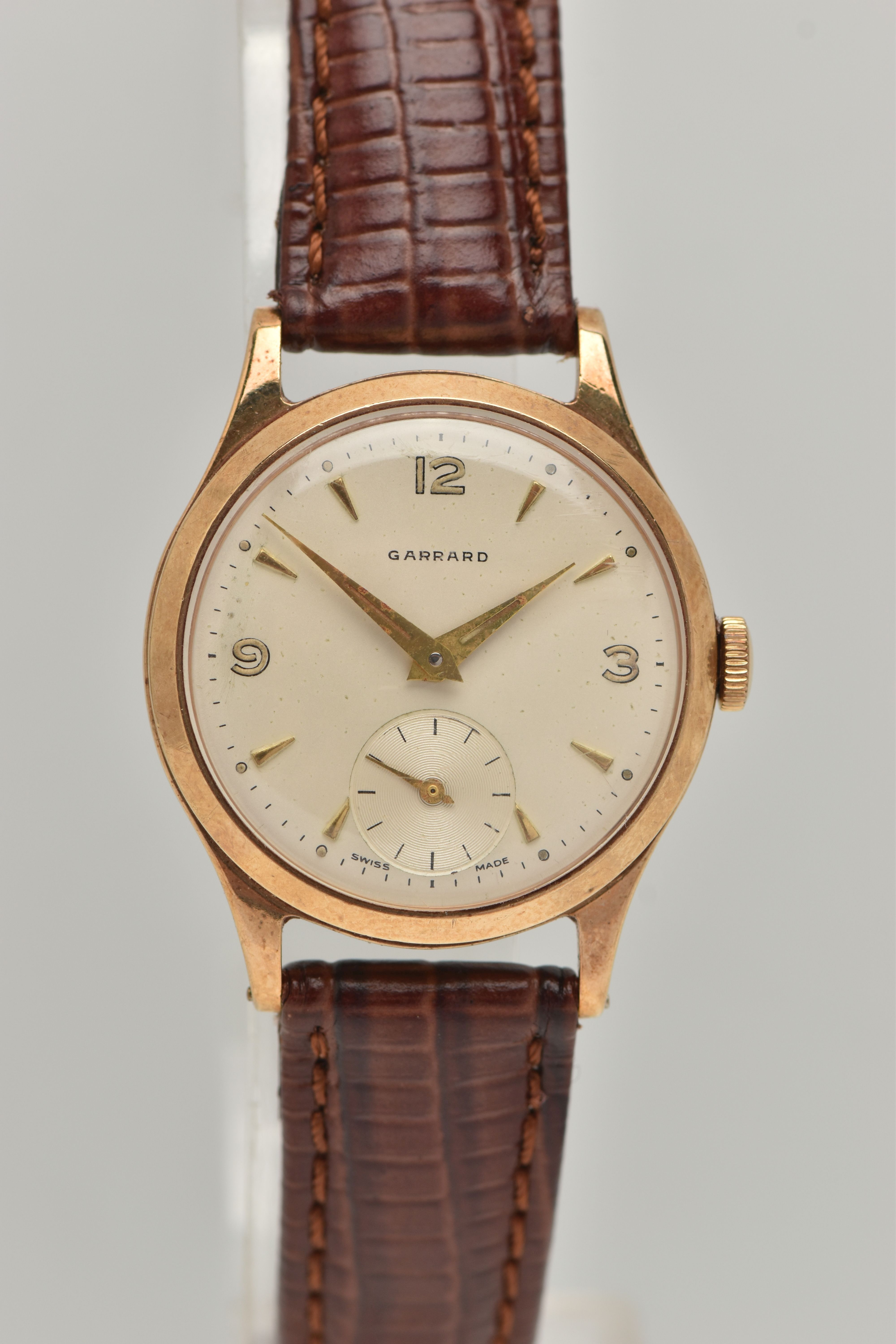 A GARRARD 9CT WRISTWATCH, the circular face with baton and Arabic numerals, a subsidiary seconds