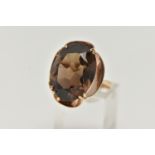 A 9CT GOLD SMOKY QUARTZ DRESS RING, designed as a large oval smoky quartz within a scalloped setting